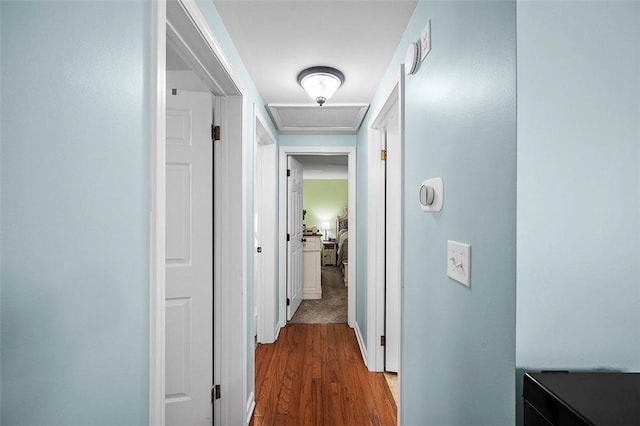 hall with attic access and wood finished floors