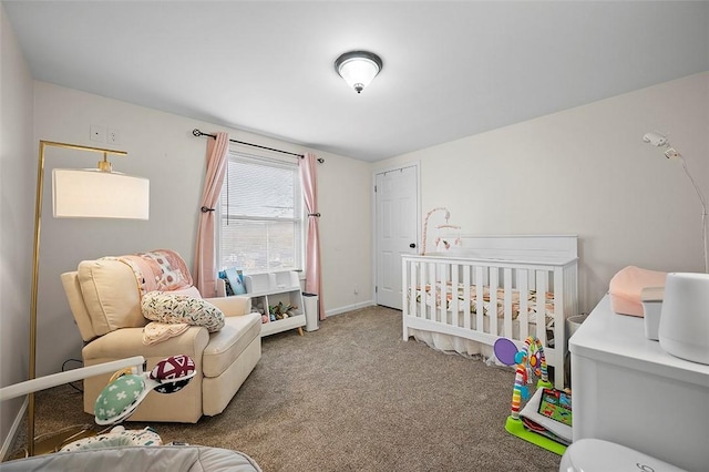 bedroom featuring carpet, a crib, and baseboards