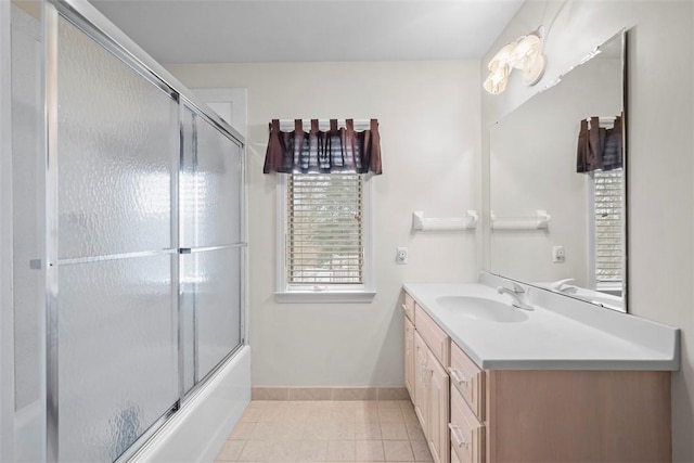 bathroom with tile patterned flooring, enclosed tub / shower combo, vanity, and baseboards