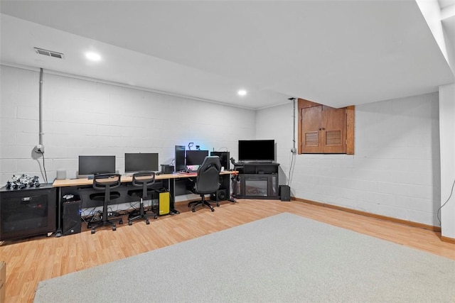 office featuring concrete block wall, visible vents, wood finished floors, and recessed lighting