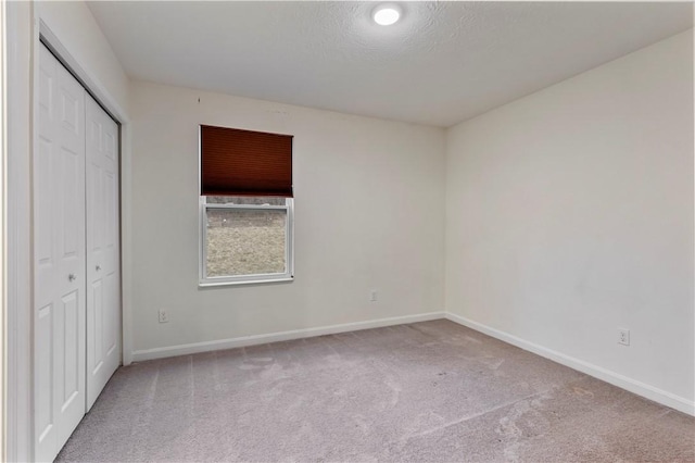 unfurnished bedroom with a closet, carpet, and baseboards