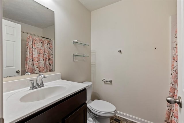 bathroom with toilet, baseboards, and vanity