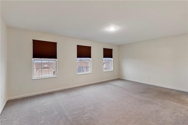 carpeted spare room with baseboards