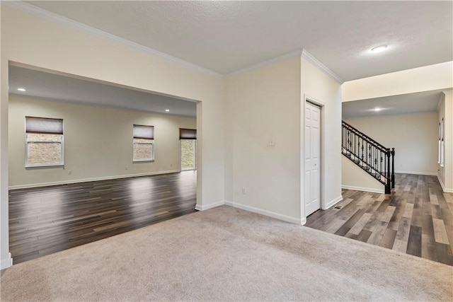 unfurnished room with ornamental molding, stairway, carpet, and baseboards