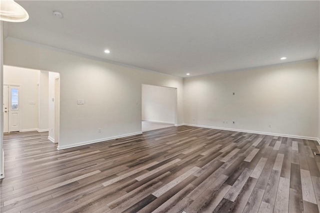 spare room featuring baseboards, ornamental molding, wood finished floors, and recessed lighting