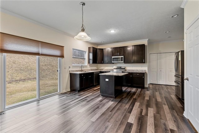 kitchen featuring stainless steel appliances, dark brown cabinets, ornamental molding, a center island, and dark wood finished floors