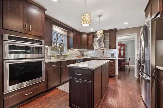 kitchen featuring appliances with stainless steel finishes, dark wood-style flooring, a sink, and decorative backsplash