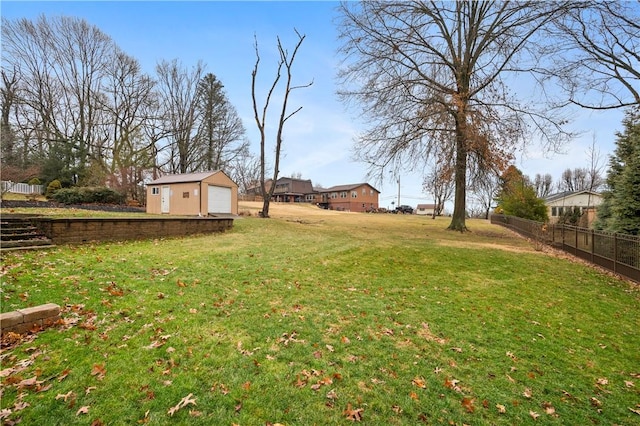 view of yard with a garage, fence, and an outdoor structure