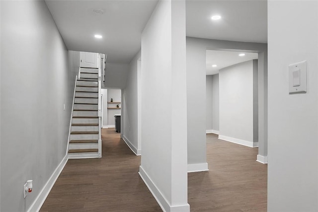 hall featuring dark wood-style floors, recessed lighting, stairs, and baseboards