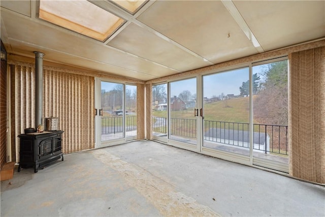 unfurnished sunroom with a wealth of natural light and a wood stove