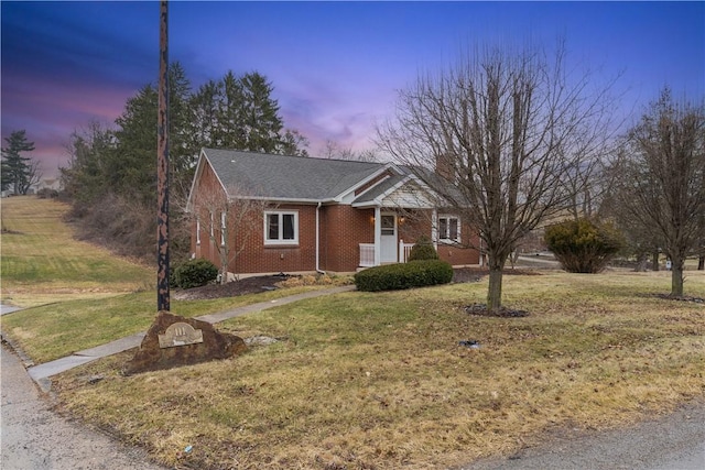 view of front of home with brick siding and a front yard