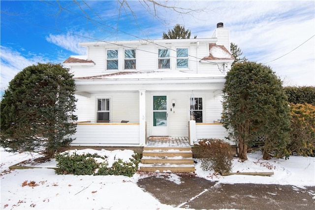 view of front of home with covered porch and a chimney