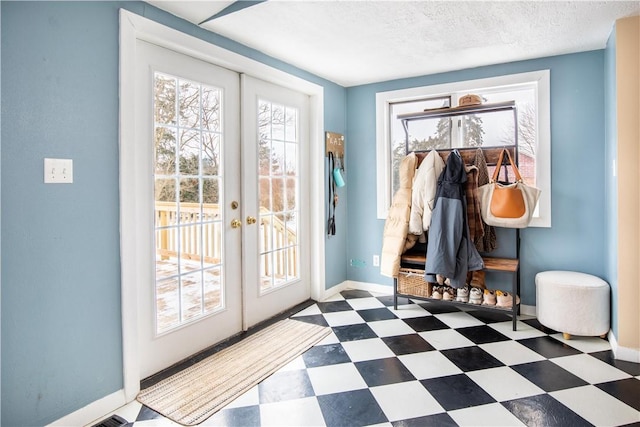 mudroom featuring french doors, a textured ceiling, baseboards, and tile patterned floors