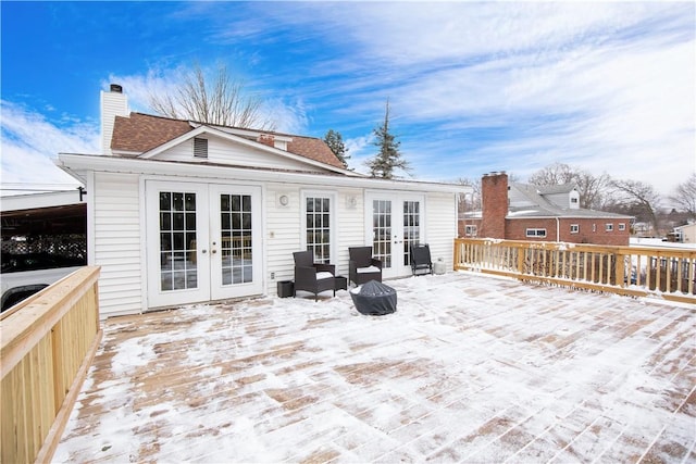 back of house featuring a chimney, a deck, and french doors