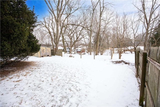 yard layered in snow with fence and an outdoor structure