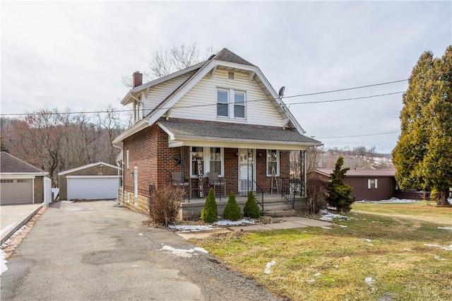 view of front of home featuring a porch, brick siding, a detached garage, an outdoor structure, and a chimney