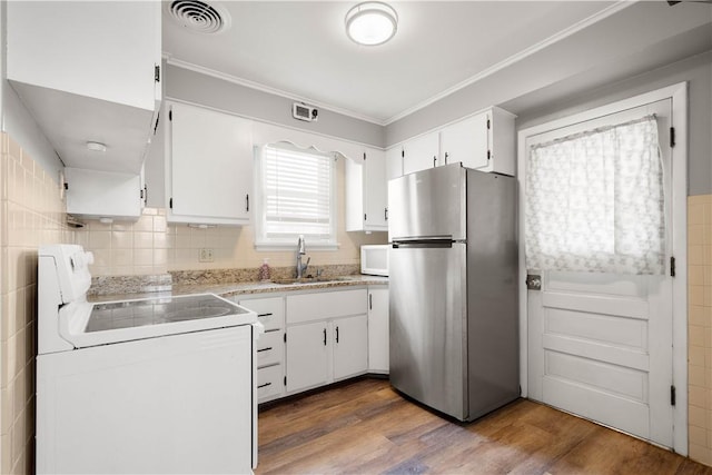 kitchen featuring white appliances, visible vents, dark wood-style floors, white cabinetry, and a sink