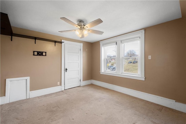 spare room with carpet floors, baseboards, and a ceiling fan