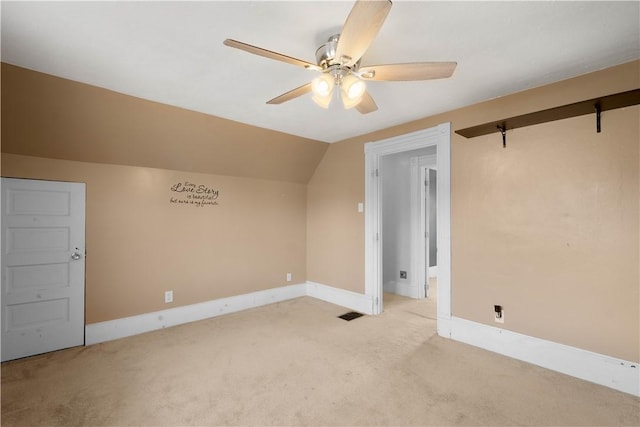 additional living space featuring light carpet, ceiling fan, baseboards, and vaulted ceiling