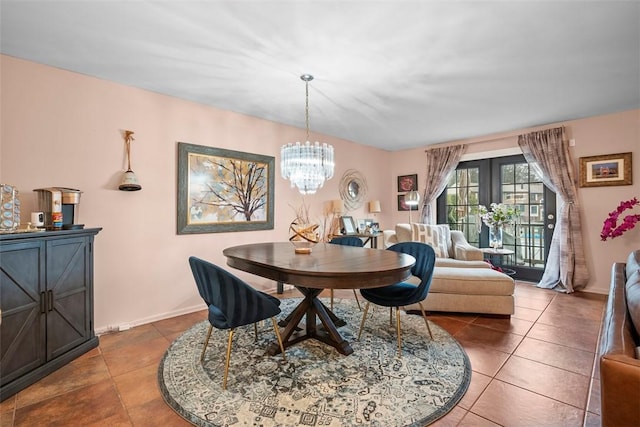 tiled dining space featuring baseboards, french doors, and a notable chandelier