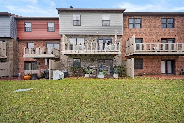 back of property with brick siding, a lawn, and central air condition unit