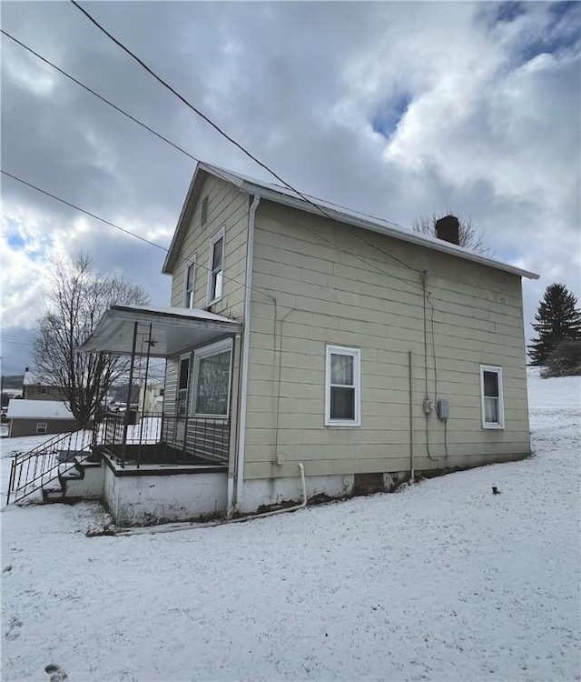 snow covered property featuring covered porch