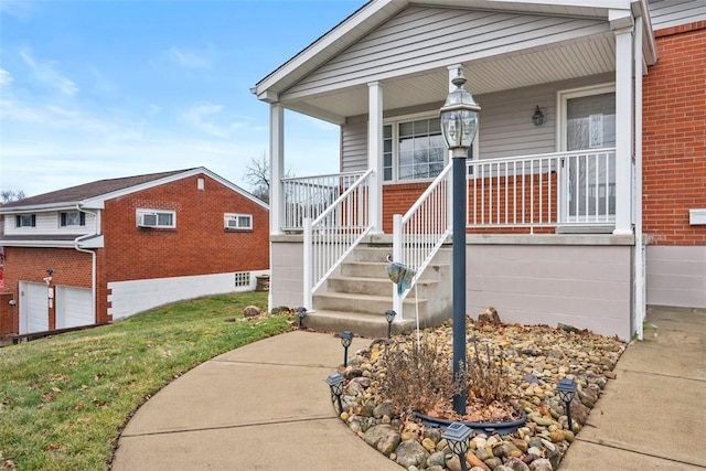 view of exterior entry with covered porch and brick siding