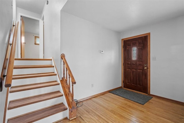 entrance foyer with stairs, baseboards, and wood finished floors