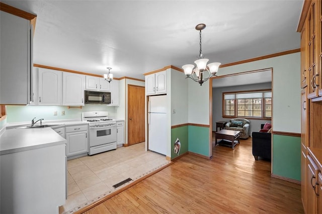 kitchen featuring white appliances, visible vents, crown molding, light wood-style floors, and a sink