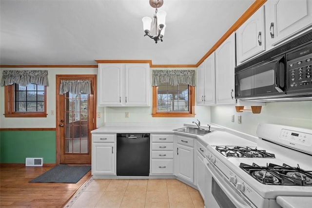 kitchen with white cabinets, visible vents, a sink, and black appliances