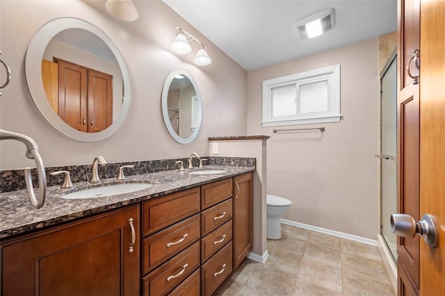 bathroom with toilet, double vanity, baseboards, and a sink