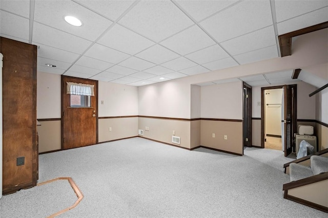 below grade area featuring carpet floors, a paneled ceiling, visible vents, and baseboards