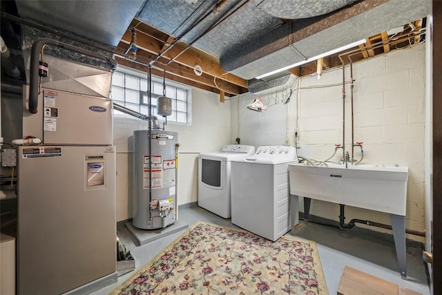 washroom featuring water heater, laundry area, washing machine and clothes dryer, and heating unit