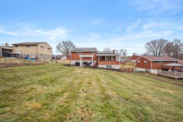 rear view of property with a yard, fence, and a residential view