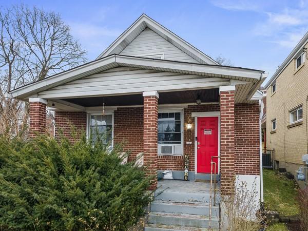 bungalow featuring brick siding