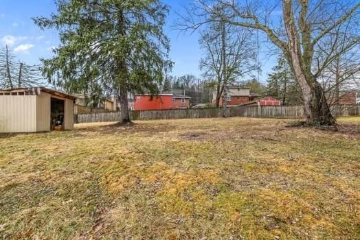 view of yard with a pole building, an outdoor structure, and fence