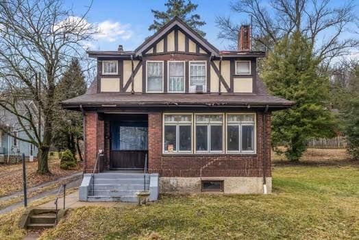 exterior space with a chimney, a lawn, and brick siding