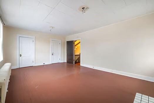 unfurnished room featuring finished concrete floors and baseboards