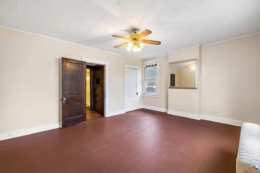 unfurnished bedroom featuring radiator heating unit, baseboards, and a ceiling fan