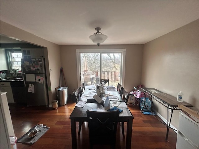 dining room with baseboards and dark wood-style flooring