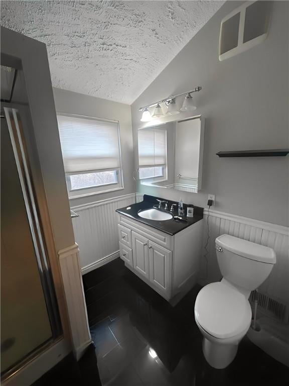 bathroom with a wainscoted wall, lofted ceiling, toilet, a textured ceiling, and vanity