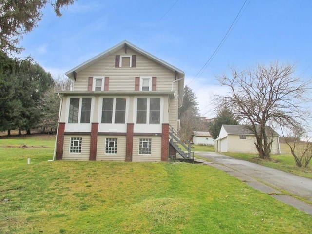 view of front of home with stairs, driveway, a front lawn, and a sunroom