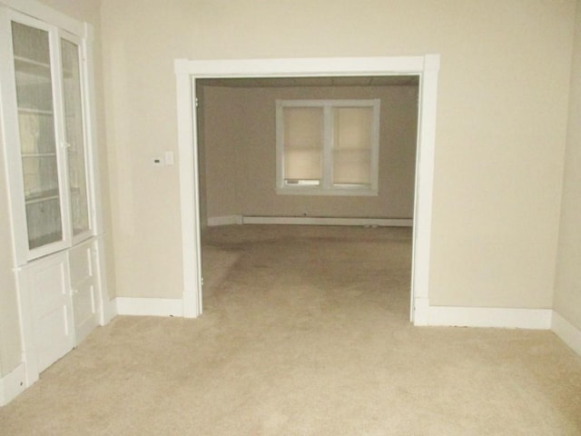 hall featuring light carpet and baseboards