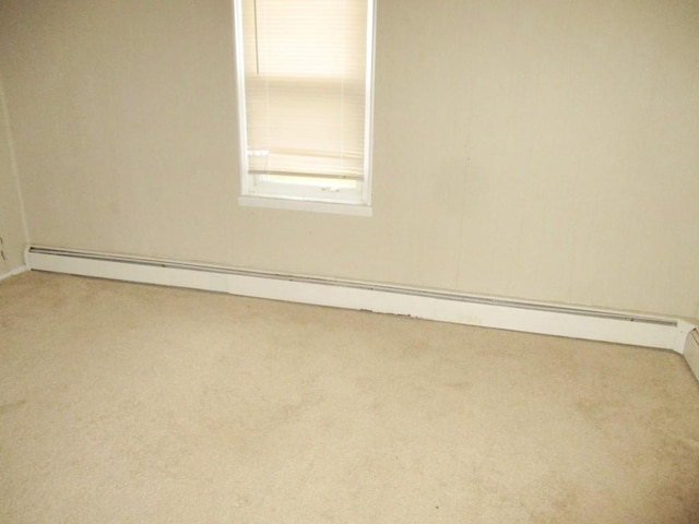 carpeted spare room featuring baseboard heating