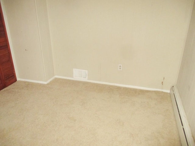 spare room with light colored carpet, baseboards, visible vents, and baseboard heating