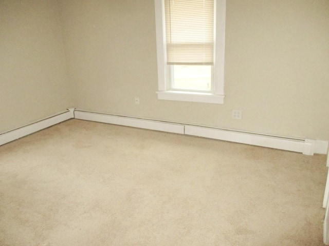 carpeted spare room featuring baseboard heating