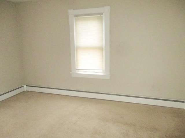 carpeted empty room featuring baseboard heating