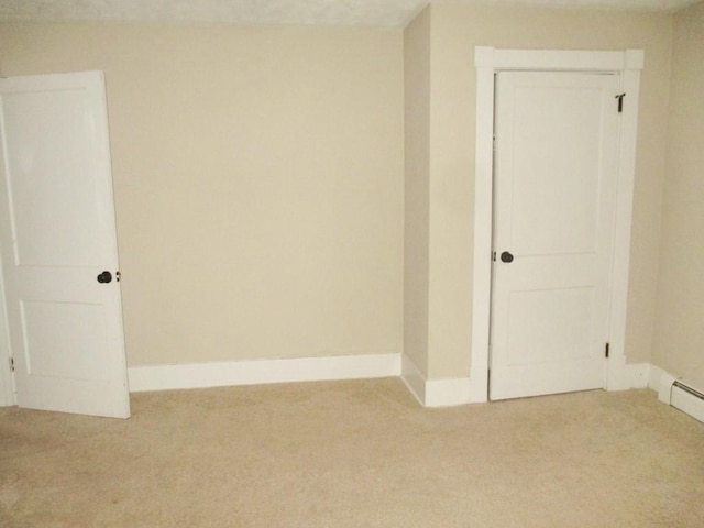 carpeted empty room featuring baseboards