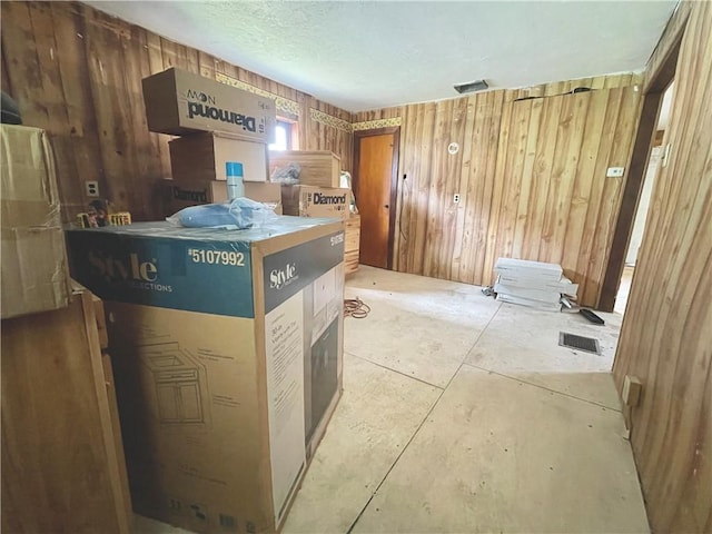 interior space featuring wooden walls and a textured ceiling