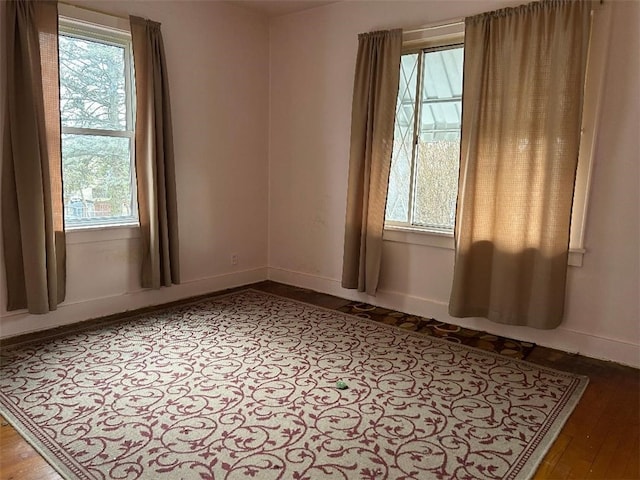 empty room with baseboards and wood finished floors